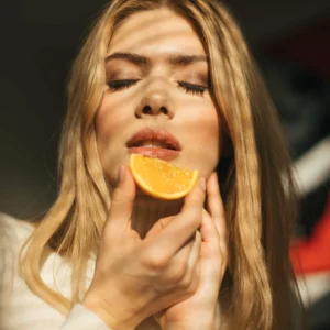 The Jet Lag Reset - A lady eating an orange, a great source of Vitamin C